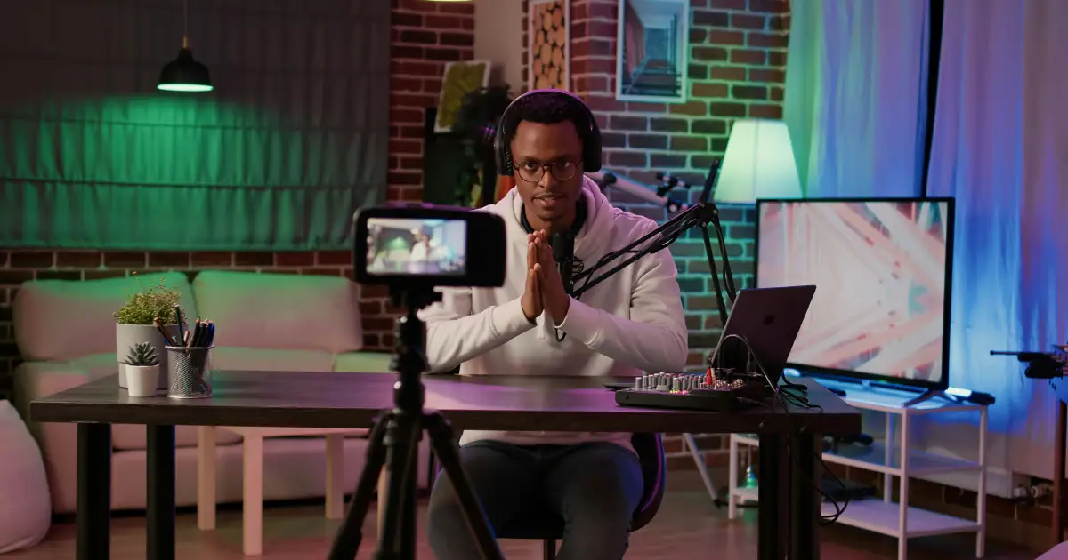 Creator editing a video at a desk with a camera and monitor