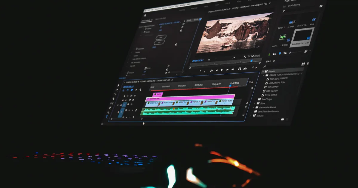 Video editing timeline open on a laptop in a dark room